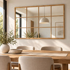 Espejo Nordic tipo ventana con marco de madera instalado sobre comedor moderno y luminoso.