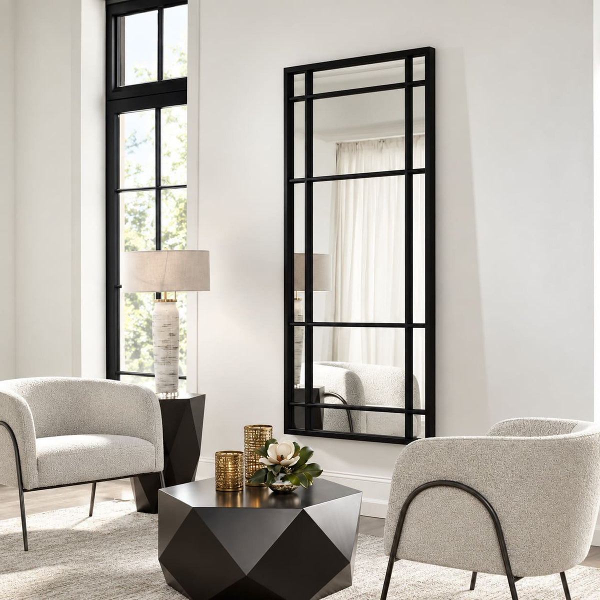 Espejo Ventana XL con marco negro instalado verticalmente en la pared de un living con sillones claros y mesa geométrica negra.