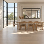 Espejo Culture horizontal con marco negro y divisiones decorativas en un comedor luminoso con mesa de madera.