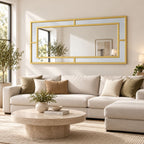 Espejo Glamour horizontal con marco dorado y diseño geométrico sobre un sofá beige en un living luminoso.