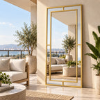 Espejo Glamour de cuerpo entero con marco dorado, colocado verticalmente en una terraza con plantas y sillones.
