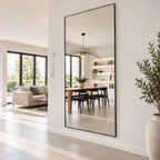 Espejo grande rectangular con marco negro en ambiente moderno junto a comedor y living.