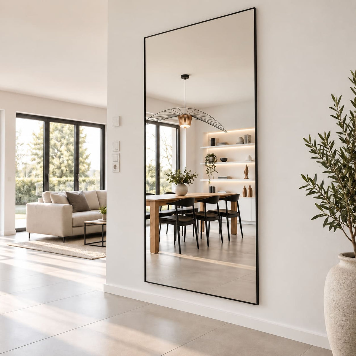 Espejo grande rectangular con marco negro en ambiente moderno junto a comedor y living.