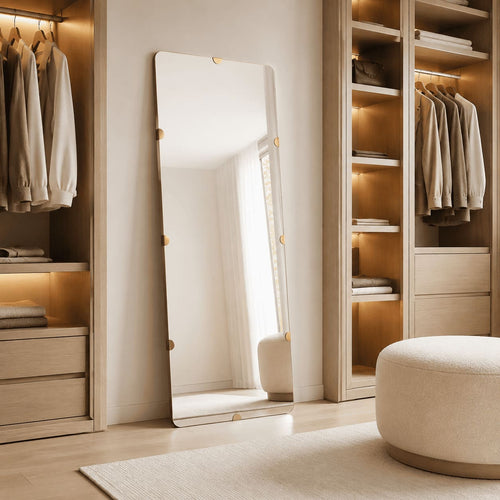 Espejo rectangular de cuerpo entero con detalles dorados entre armarios abiertos de madera en un vestidor.