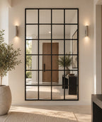 Espejo grande estilo ventana con marco negro, instalado verticalmente en un recibidor de la casa