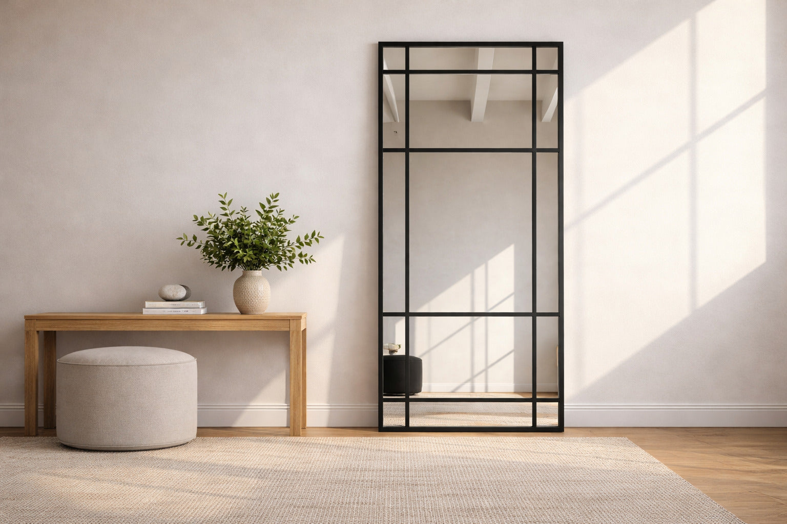 Espejo ventana XL negro apoyado en living moderno con luz natural de afuera